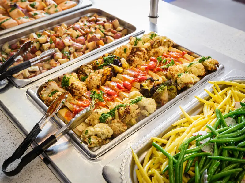 overhead shot of hot serving line with chicken and green beans